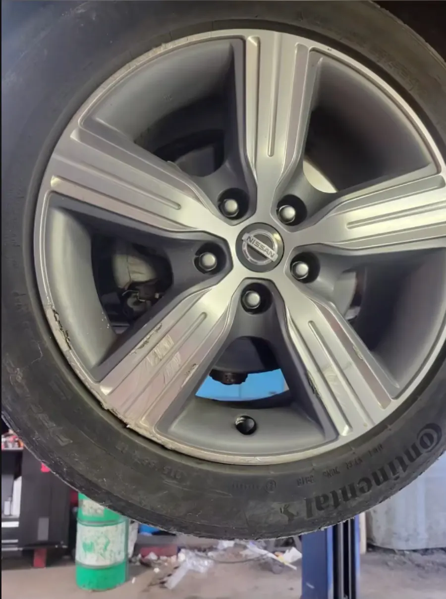Nissan alloy wheel with curb rash on the rim edge before mobile rim repair