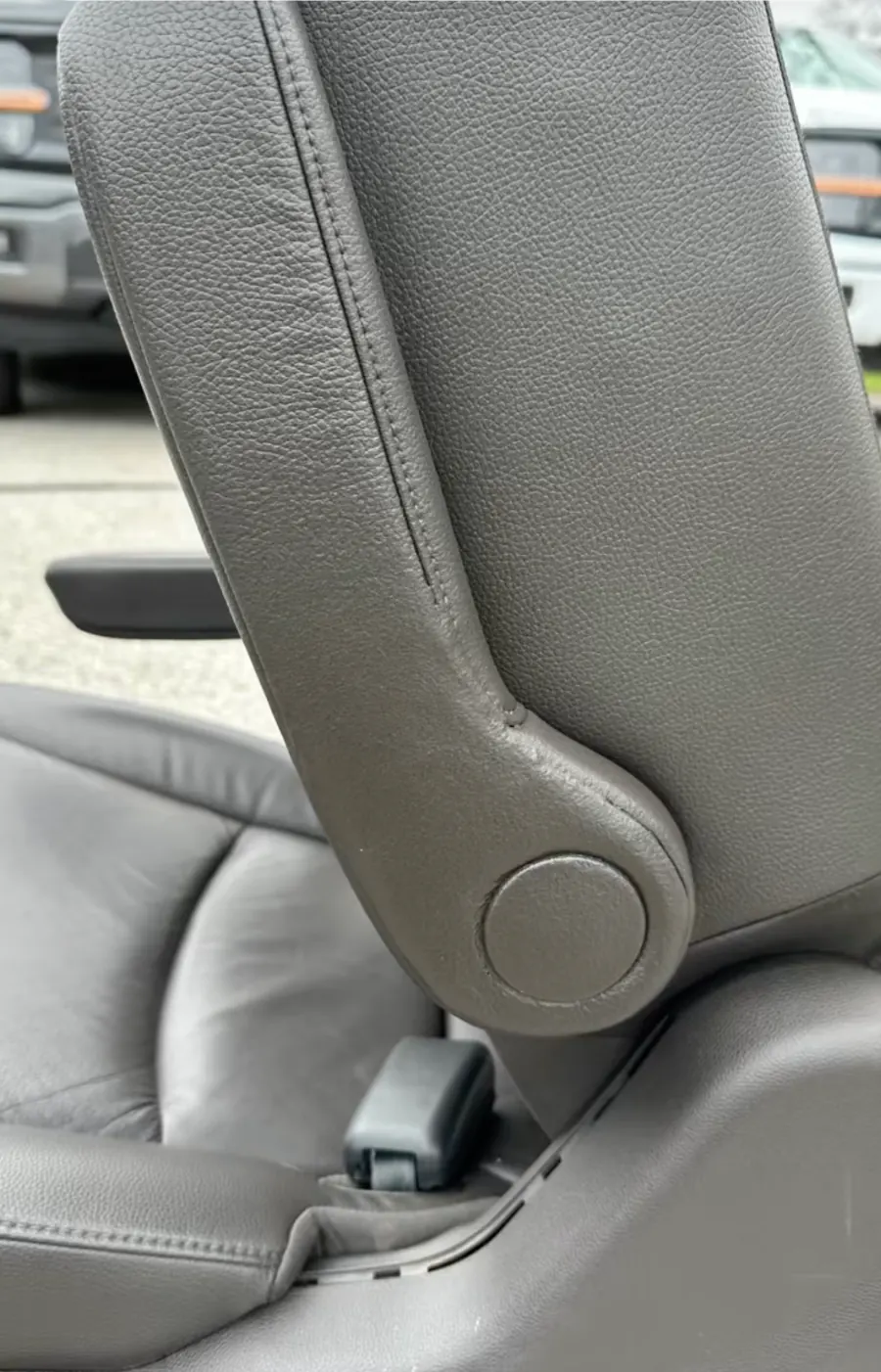 Gray leather seat back bolster after tear repair and color matching