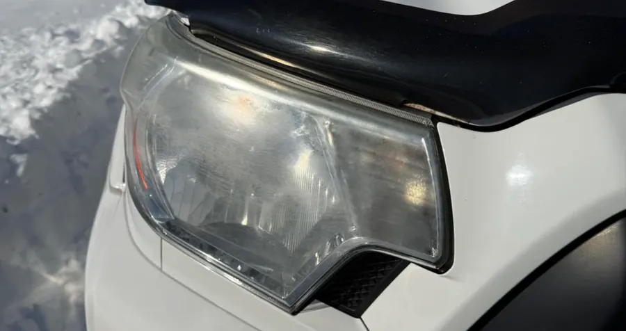Foggy, oxidized headlight lens on a white Toyota Tacoma before headlight restoration