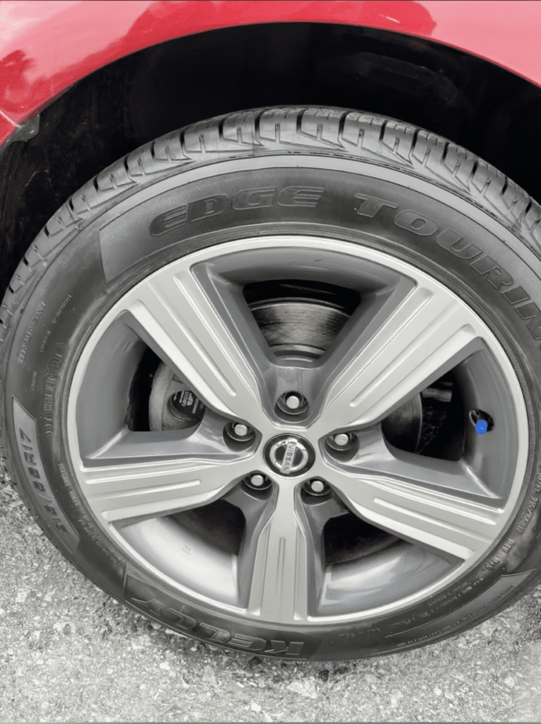 Close-up of dealership vehicle wheel showing curb rash and alloy damage repaired by Dye It Rite mobile wheel repair technicians