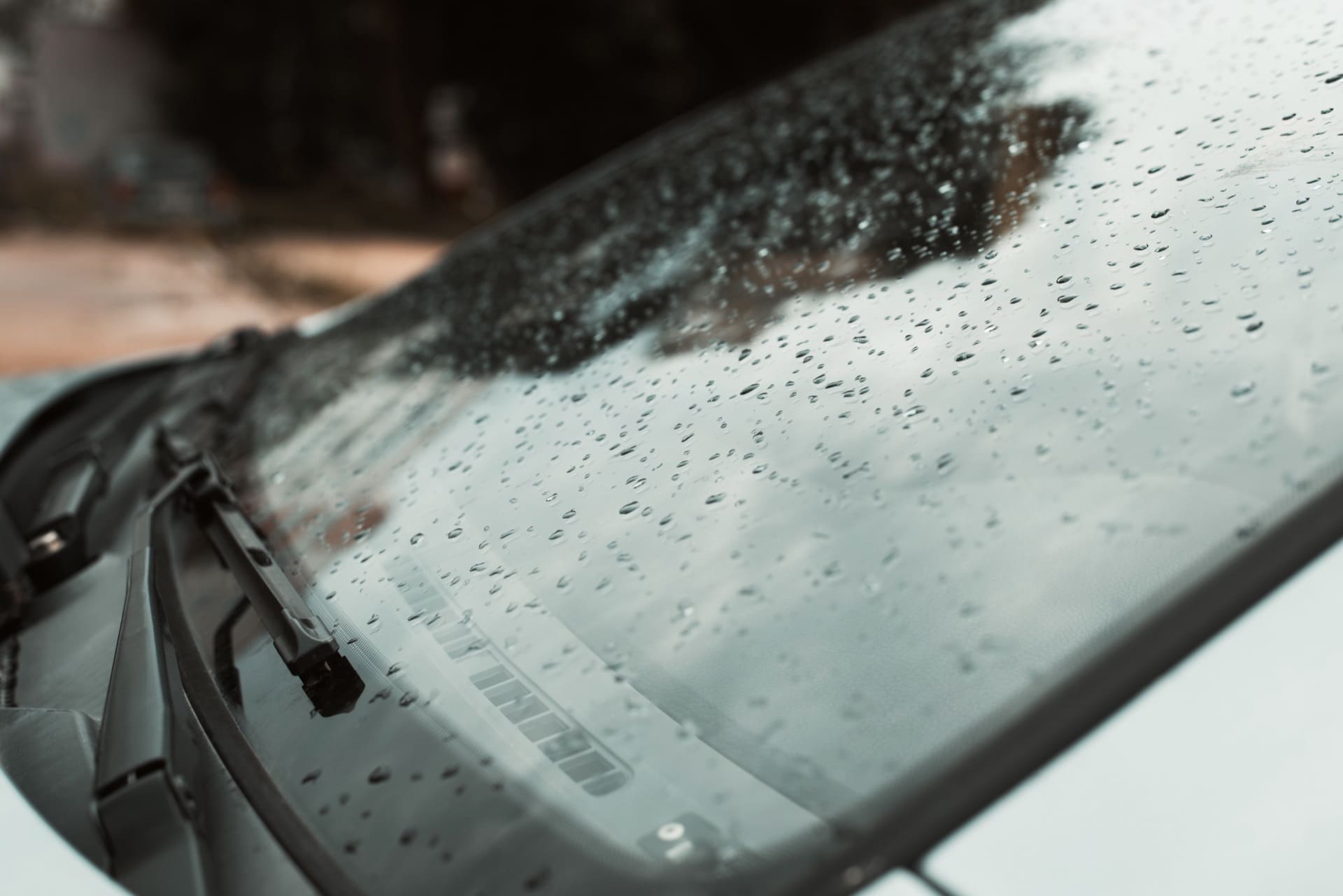 Close-up of windshield chip being repaired with professional resin during on-site dealership auto glass repair service