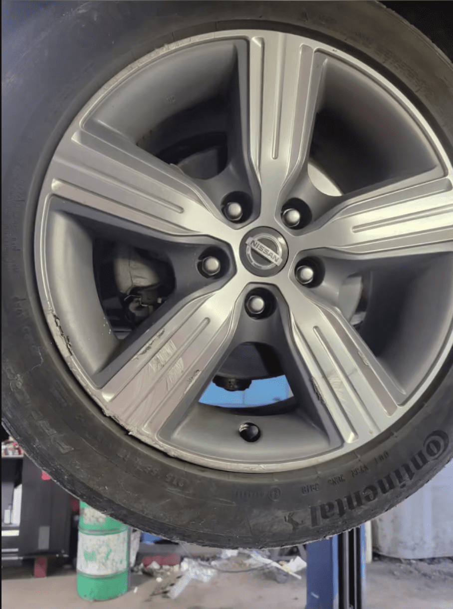 Curb rash on alloy wheel before auction vehicle reconditioning