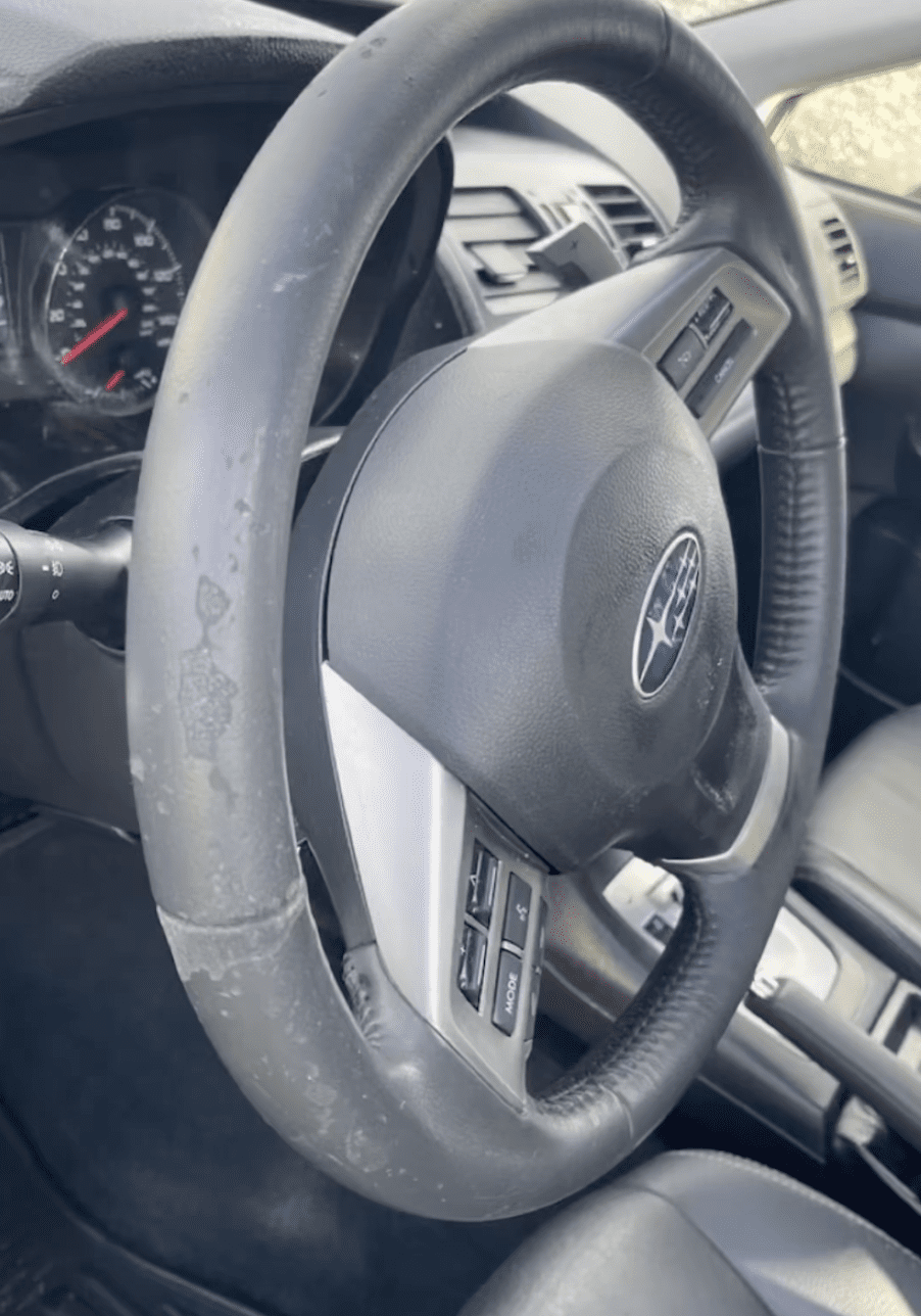 Worn steering wheel before body shop interior sublet