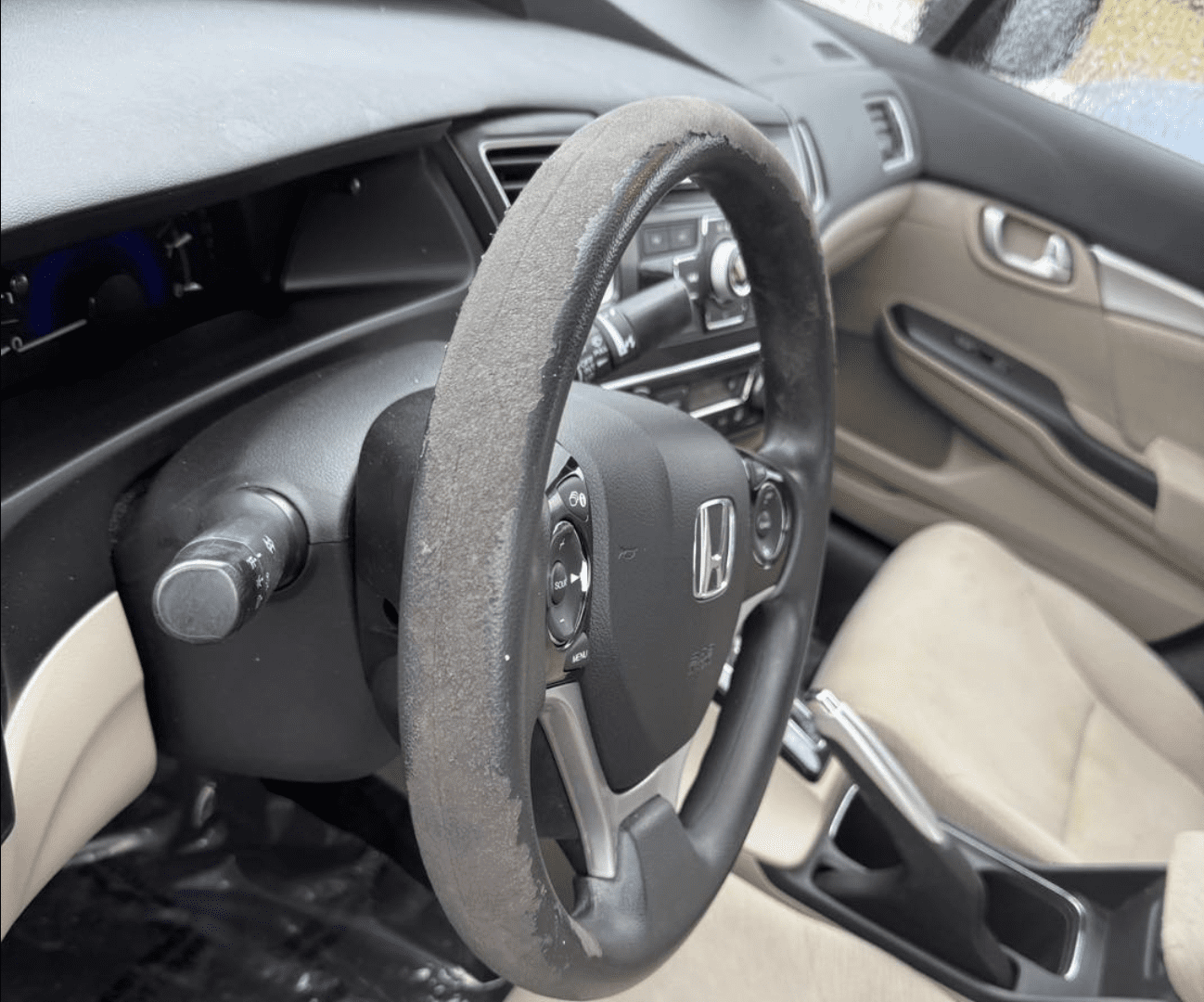 Worn seat bolster before pre-auction vehicle reconditioning