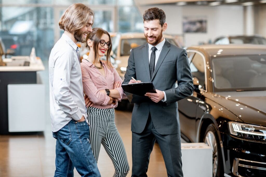 Car salesman with customers in Philadelphia dealership showroom