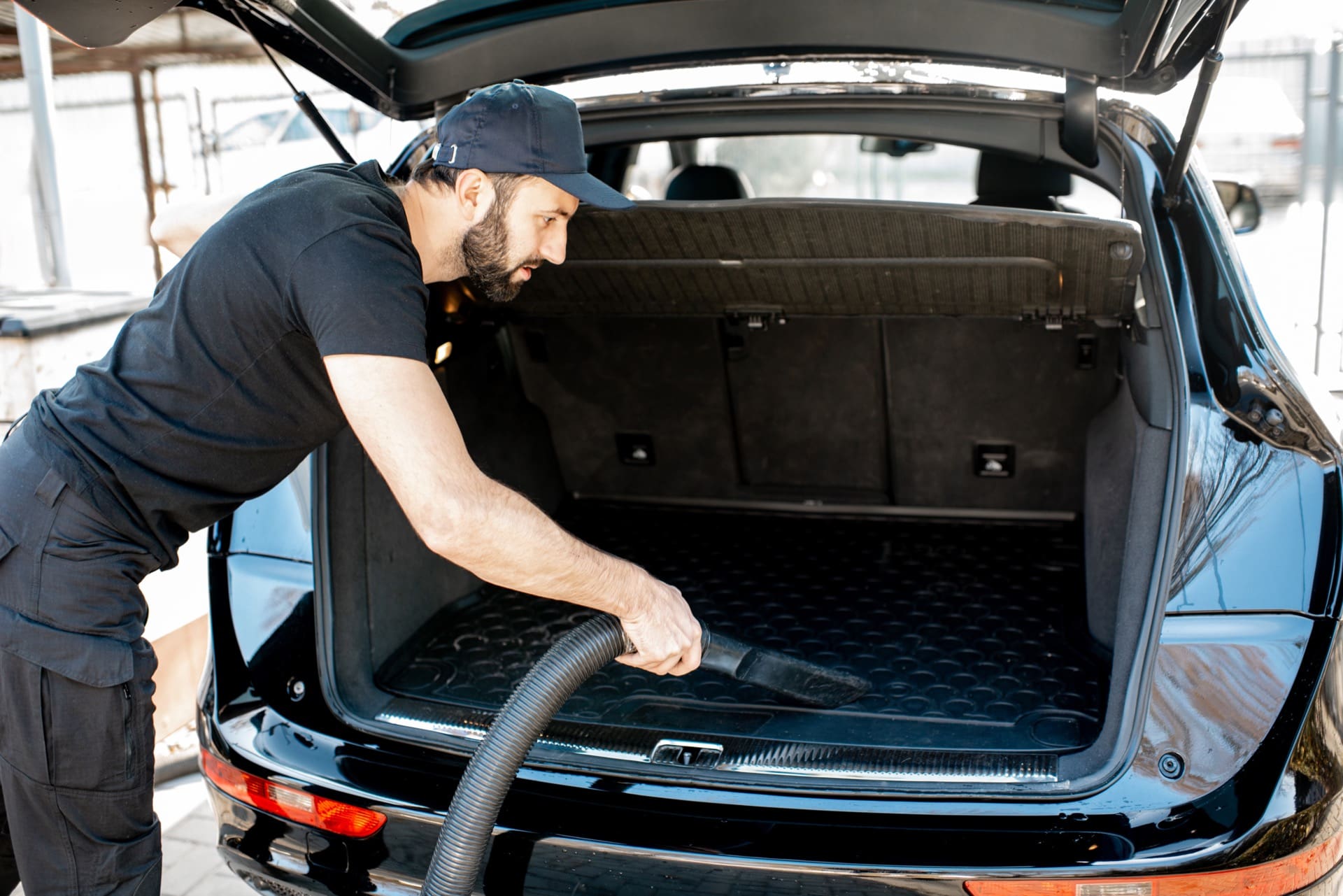 Detailer vacuuming the trunk of a car during auto detailing in Winchester VA