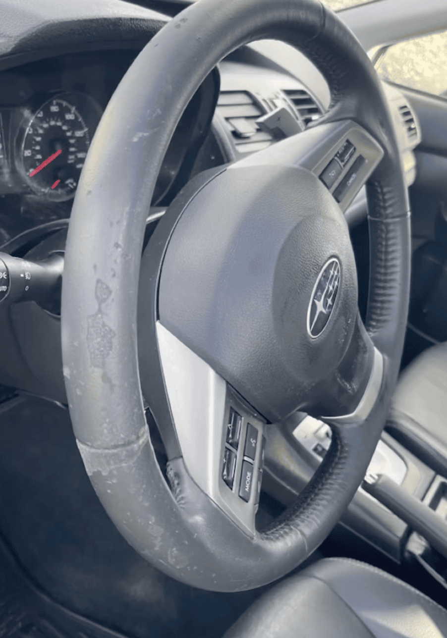 Worn steering wheel before restoration during an Allentown auto detail