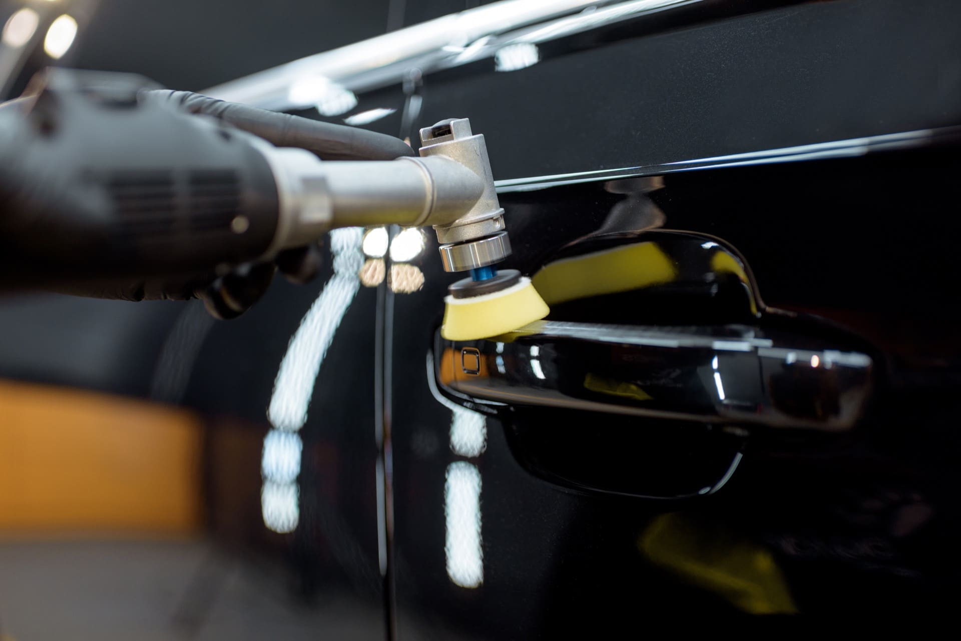 Detailer performing paint correction with a power buffer, professional auto detailing services in Allentown